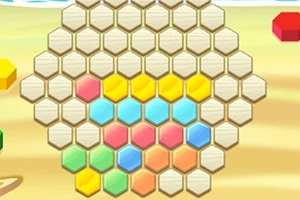 Barevné hexagonální dílky uspořádané v tvaru plástve na písčitém pozadí