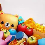 Barevné kreslené předměty zahrnující plyšového medvídka, kačenku, koblihu, jahodu, pizzu a hranolky na bílém pozadí