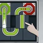 Ruka posouvá zelený dílek potrubí v logické hře s koulí na hrací desce