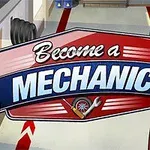 Ilustrace s nápisem Become a Mechanic a postavou blond muže v červených šatech v dílně