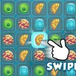 Hra obsahuje mřížku s barevnými sladkostmi a šipkou s nápisem SWIPE