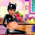 Těhotná žena v černém kostýmu s ušima sedí v kuchyni obklopená dekoracemi