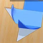 Modrý, bílý a oranžový papír poskládaný do geometrického tvaru na dřevěném povrchu