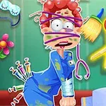 Postava s vystrašeným výrazem má na sobě modrý plášť, obličej a tělo zamotané do obvazů a injekce na zadní straně, zatímco kolem ní jsou rozptýlené lékařské nástroje a květina