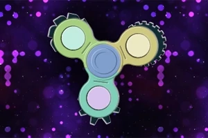 Barevný trojramenný fidget spinner ve tvaru ozubených kol na fialovém pozadí s bokeh efektem