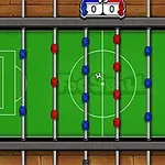 Stolní fotbal z ptačí perspektivy s červenými a modrými hráči na zeleném hřišti