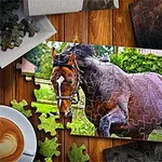 Puzzle s obrázkem hnědého koně běžícího na pastvině, obklopené zelení, na dřevěném stole vedle šálku kávy