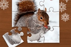 Puzzle s obrázkem veverky, která drží oříšek v zimním prostředí, s chybějícím dílkem vlevo dole