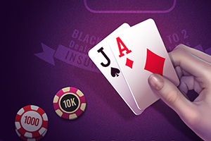 Ruka držící karty J a A na fialovém herním stole s pokerovými žetony v hodnotách 1000 a 10k