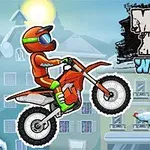 Motorkář v oranžovém oblečení skáče s motocyklem na zimní vesnické scéně vedle nazdobeného vánočního stromku