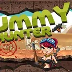 Nápis MUMMY HUNTER s obrázkem postavy s červenými vlasy a ochrannými brýlemi, držící zbraň na pozadí pouštní krajiny s ruinami