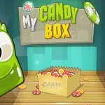 Zelený animovaný charakter s velkými očima vedle krabice plné sladkostí a nápisu My Candy Box