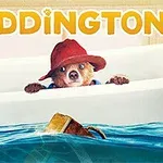 Medvídek s červeným kloboukem vykukuje z vany vedle hračky gumové kachničky, nahoře nápis PADDINGTON