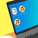 Na obrázku je laptop s modrou obrazovkou, kde jsou ikony dvou hudebních souborů, textového dokumentu a koše