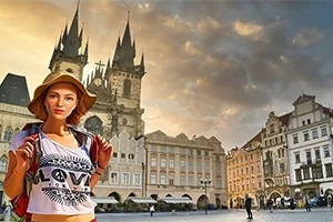 Žena s kloboukem a batohem stojí před historickými budovami na náměstí v Praze při západu slunce