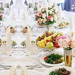Elegantní svátečně prostřený stůl s květinovými aranžmá a pečlivě servírovanými pokrmy
