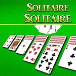 Hromádky hracích karet na zeleném podkladu s nápisem Solitaire nahoře