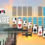 Karty rozložené na virtuální hrací ploše s nápisem Solitaire Zen Earth Edition na pozadí scenérie s jezerem a západem slunce