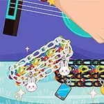 Ruka hrající na kytaru s náramky s přívěsky ve tvaru králíčka, měsíce a telefonu