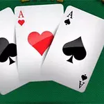 Tři karty esa klubové, srdcové a pikové leží na zeleném stole